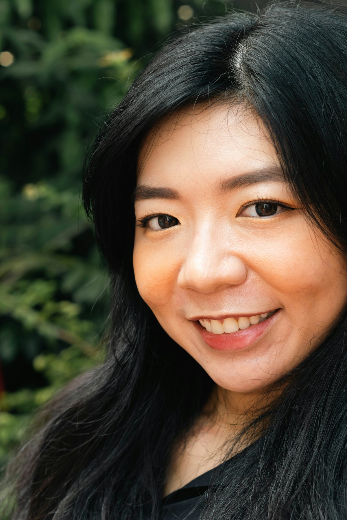 Close-up portrait of a woman smiling outdoors