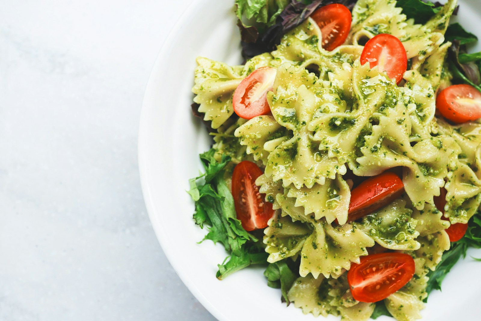 Pesto bow-tie pasta with tomatoes and leafy greens