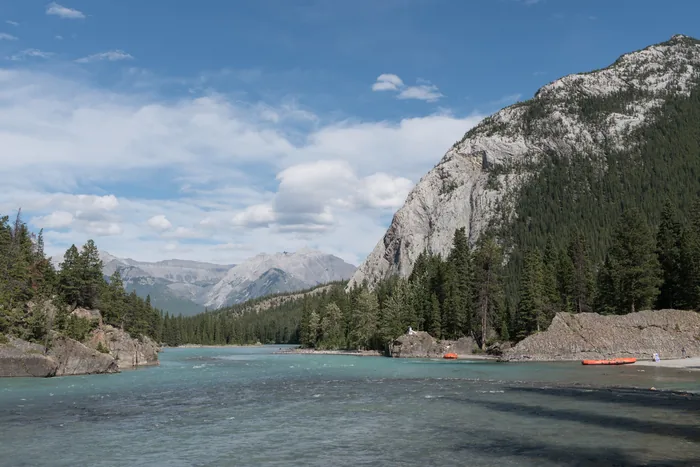 The Bow River flowing beneath mountain cliffs near Banff