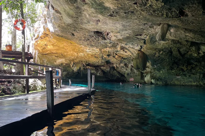 Clear blue water beneath a rock overhang at Cenote Dos Ojos