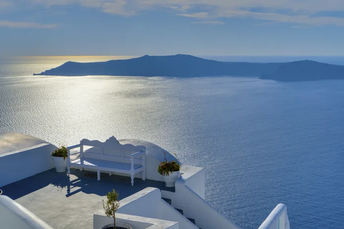 A sunlit terrace overlooking the Aegean from Oia, Santorini